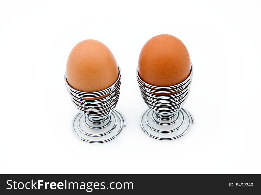 Two eggcups with eggs, isolated on white