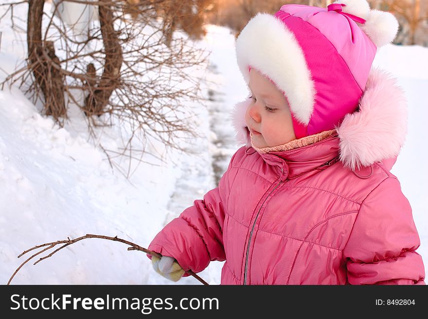 Pretty little girl drawing on the snow.