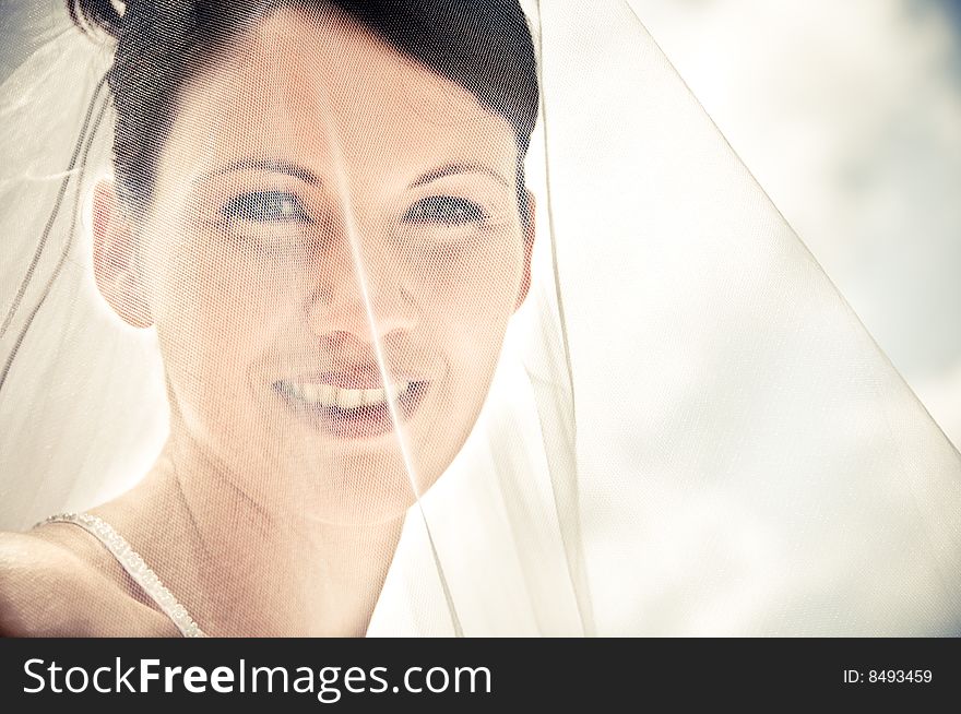 White Bride at her wedding posing with veil