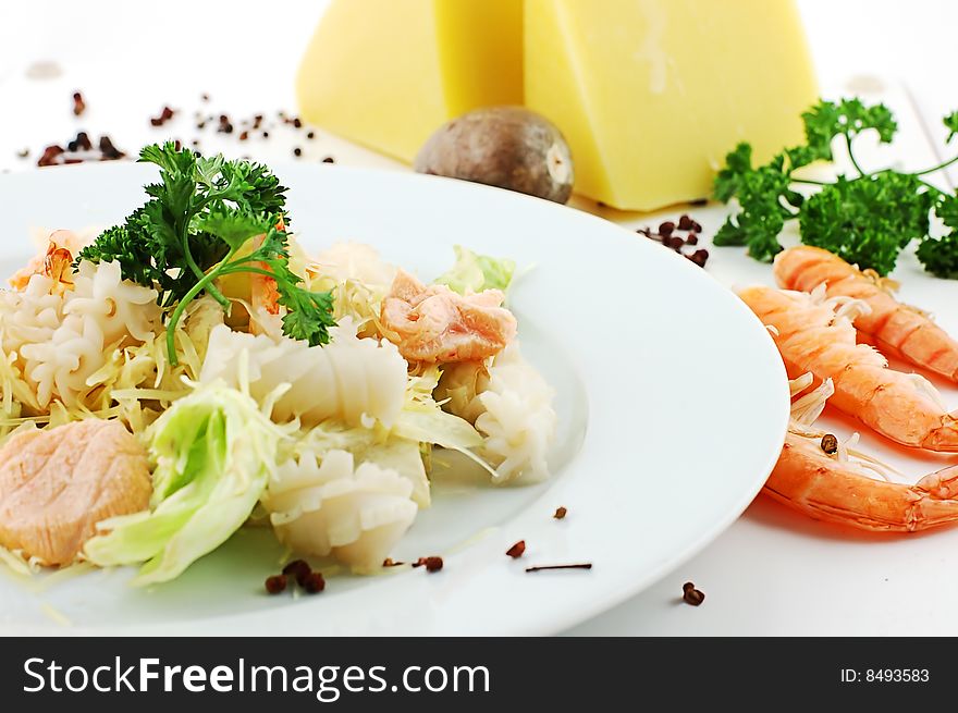 Salad with cheese and shrimps on a white dish. Salad with cheese and shrimps on a white dish