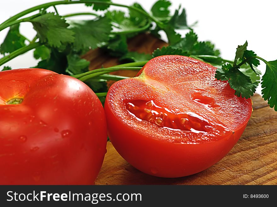 Tomato and coriander on wooden plate