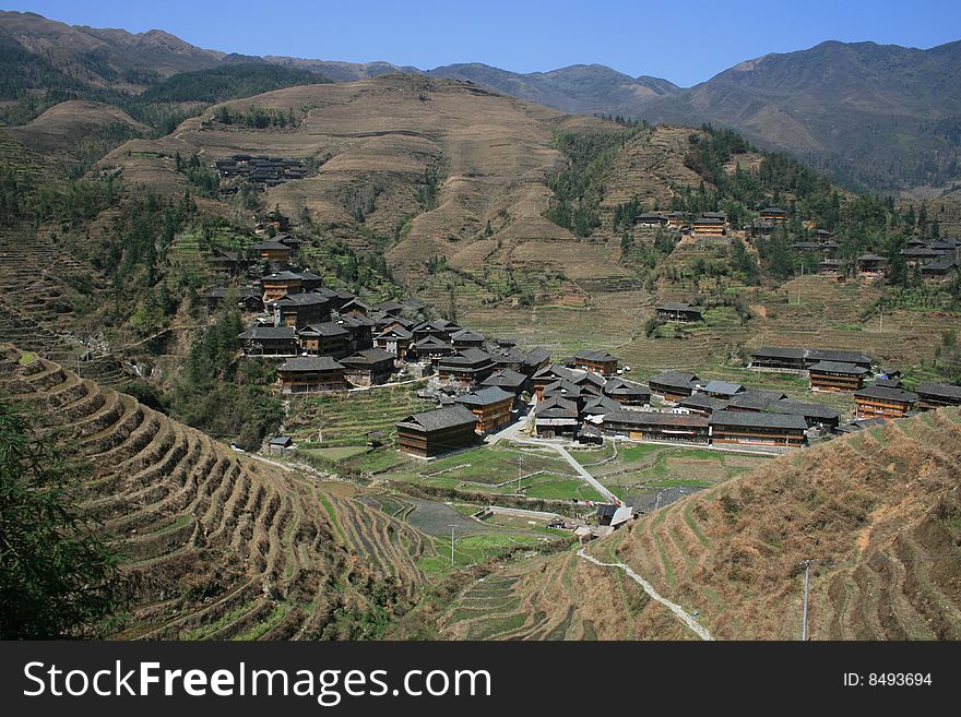 A Chinese minority village in the middle of steep rice terrances in Guangxi Province of southern China. A Chinese minority village in the middle of steep rice terrances in Guangxi Province of southern China.