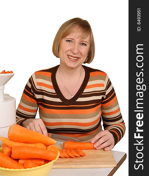 The woman slices carrots for preparation of juice. The woman slices carrots for preparation of juice
