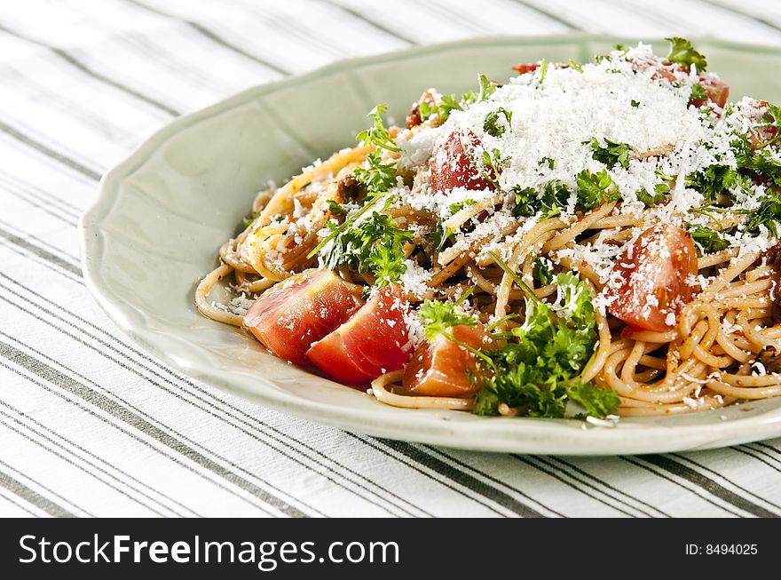 Spaghetti with tomato sauce and herbs served on rustic plate