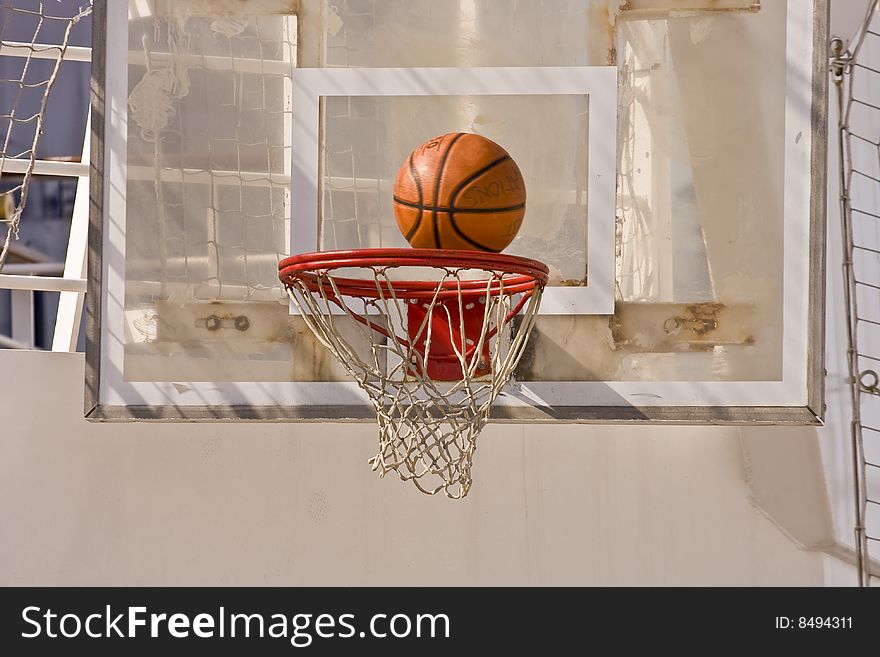 A basketball about to drop into the net. A basketball about to drop into the net