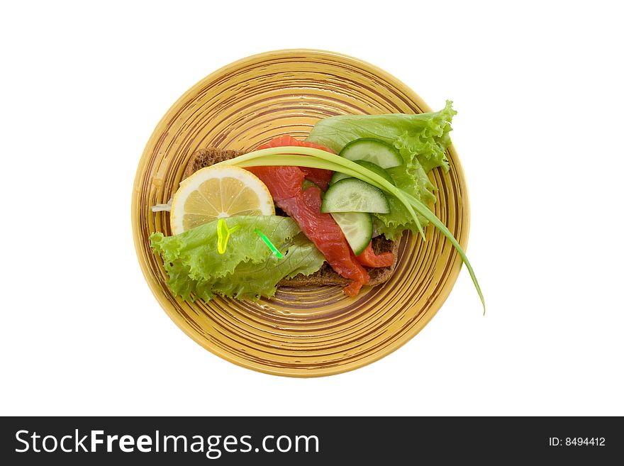 A sandwich with smoked fish; salad; onion; lemon and fresh cucumber isolated on white. A sandwich with smoked fish; salad; onion; lemon and fresh cucumber isolated on white