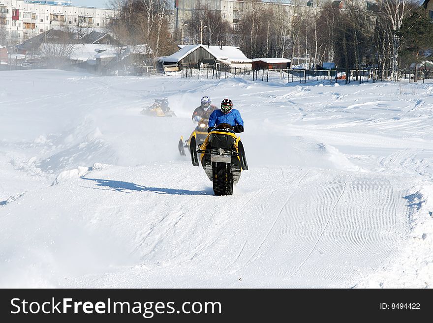 A snowmobilier takes a sharp turn through powdery snow. A snowmobilier takes a sharp turn through powdery snow.