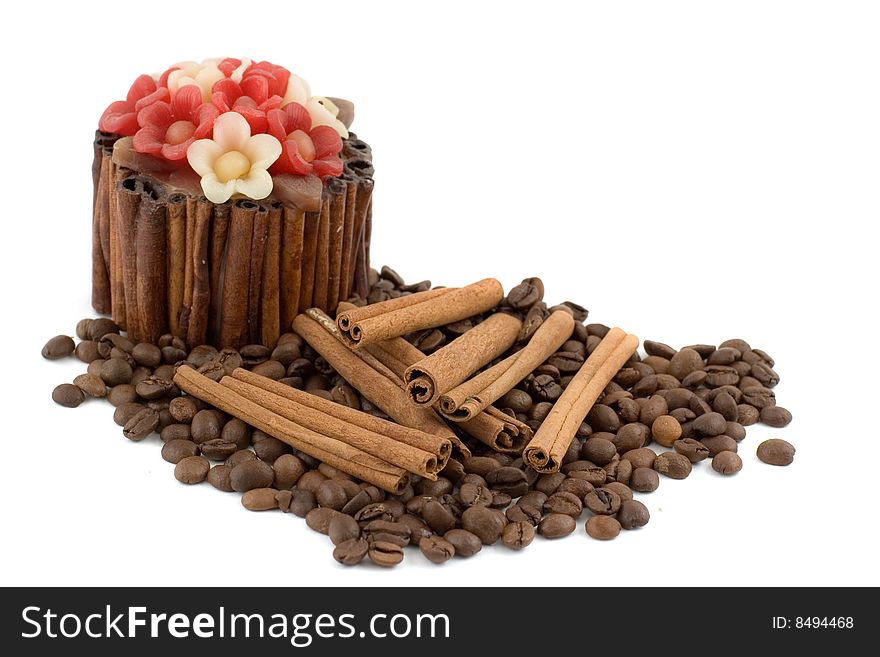 A decorative candle, pile of coffee beans and several cinnamon sticks isolated on white. A decorative candle, pile of coffee beans and several cinnamon sticks isolated on white