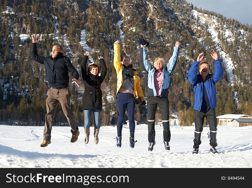 Family in a and outdoor winter setting. Jumping in joy! Slight motion bluriness is intended.