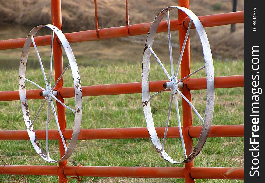 Two white wheels on a red gate. Two white wheels on a red gate