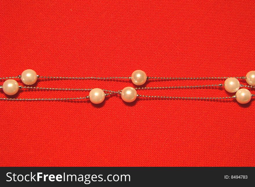 Beads from paste pearl on a red background