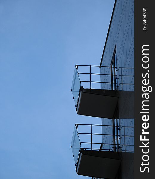 Silhouette of 2 balconies against the blue sky