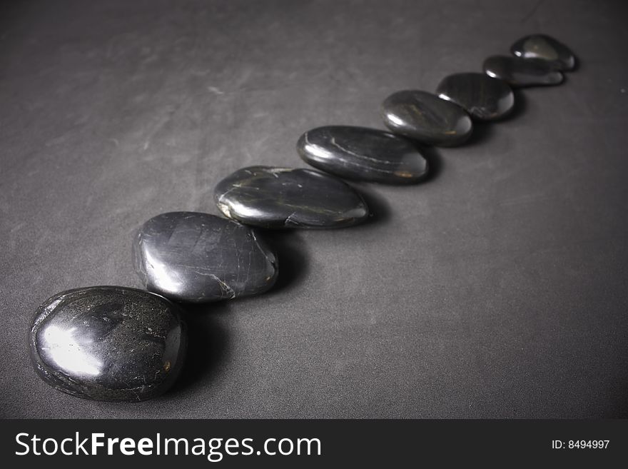 Three zen stones on a gray background.