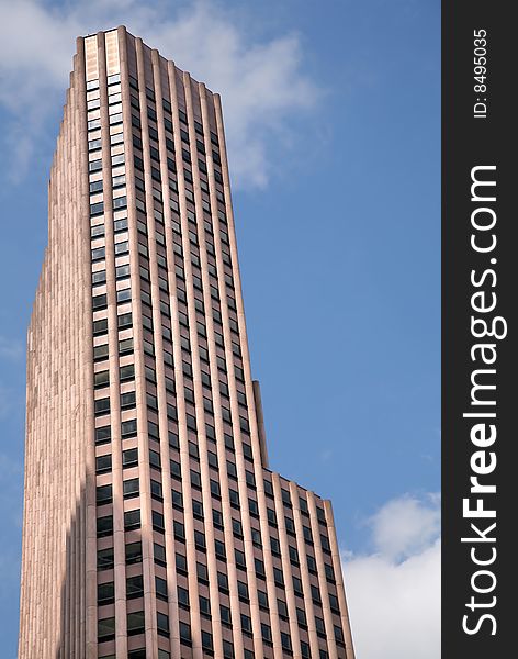 Tall Jutting Granite Building against blue sky