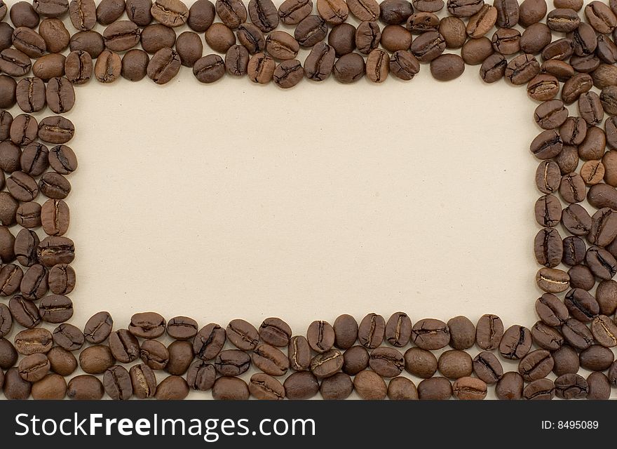 A frame made of coffee beans laid out on brown paper. A frame made of coffee beans laid out on brown paper