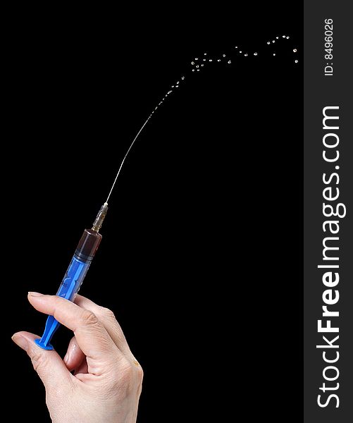 Syringe in a hand on a black background