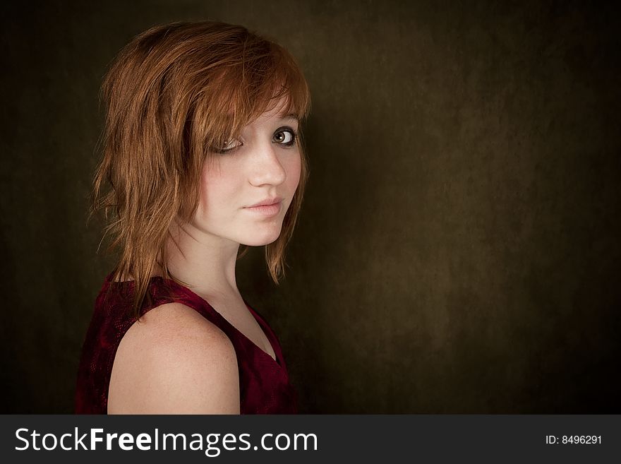 Pretty young girl with red hair on a green background. Pretty young girl with red hair on a green background