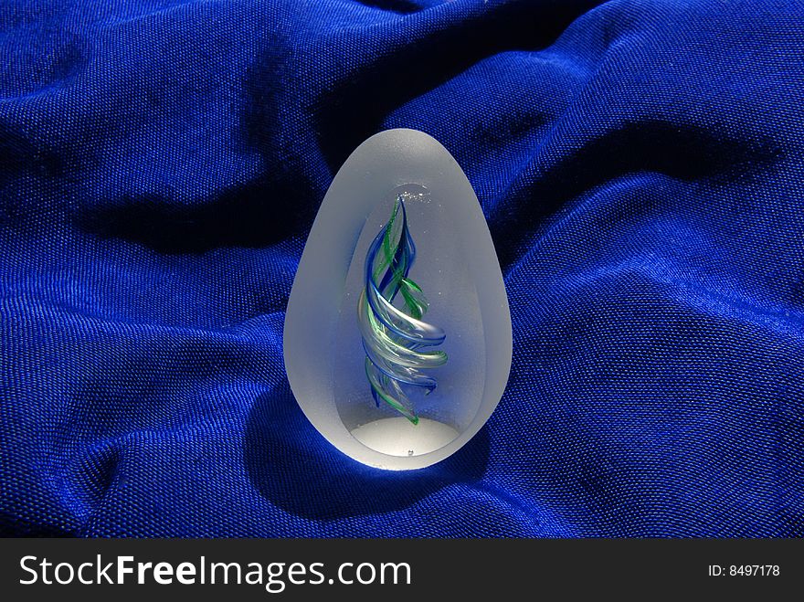 Mouth blown eggshaped glass art from Germany on blue cloth. Mouth blown eggshaped glass art from Germany on blue cloth