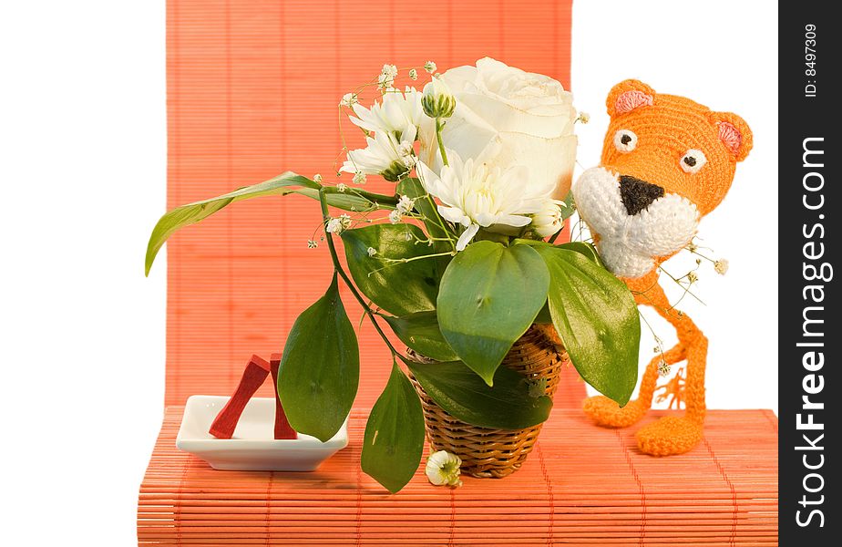 Hand made orange knitted tiger for ornamental pattern and vase with white rose