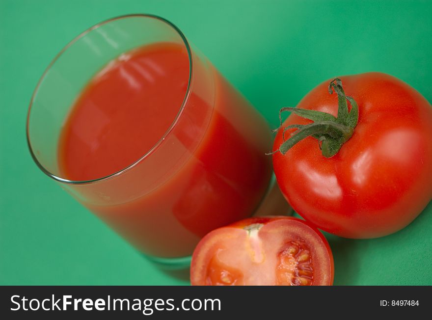 Ripe juicy tomatoes and glass of tomato juice. Ripe juicy tomatoes and glass of tomato juice