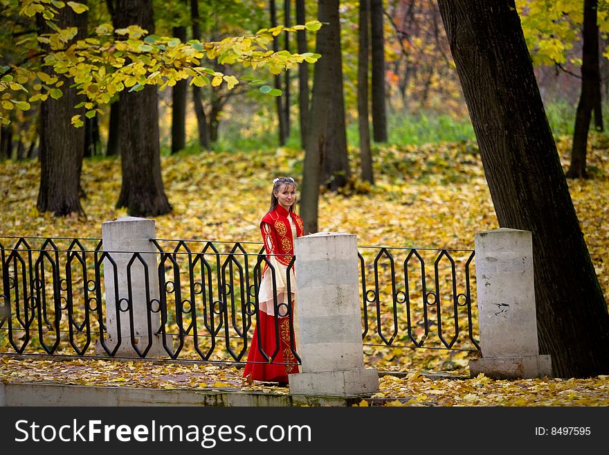 Lady in medieval red dress in the autumn forest. Lady in medieval red dress in the autumn forest
