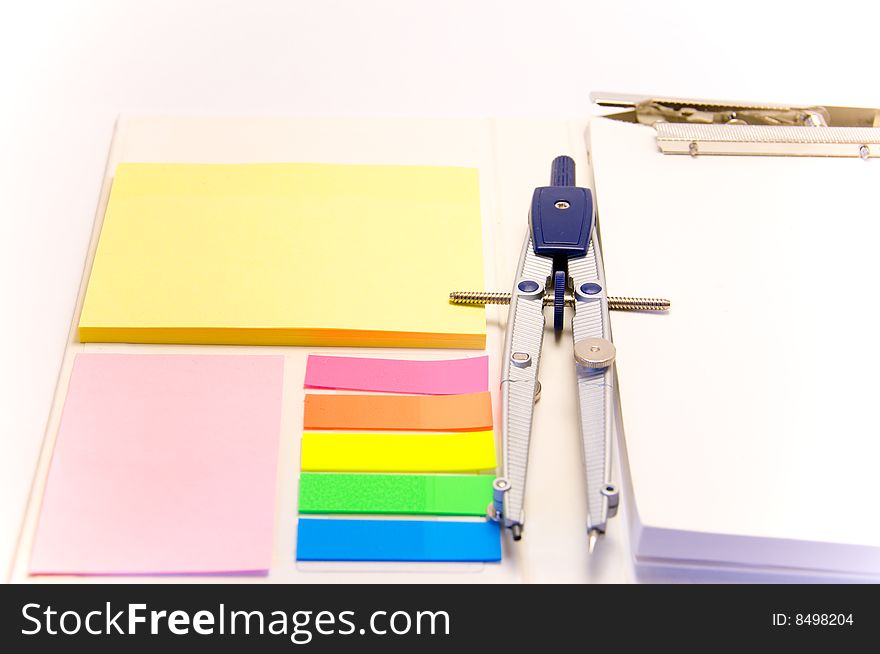 Notepad and compass on an isolated white background.