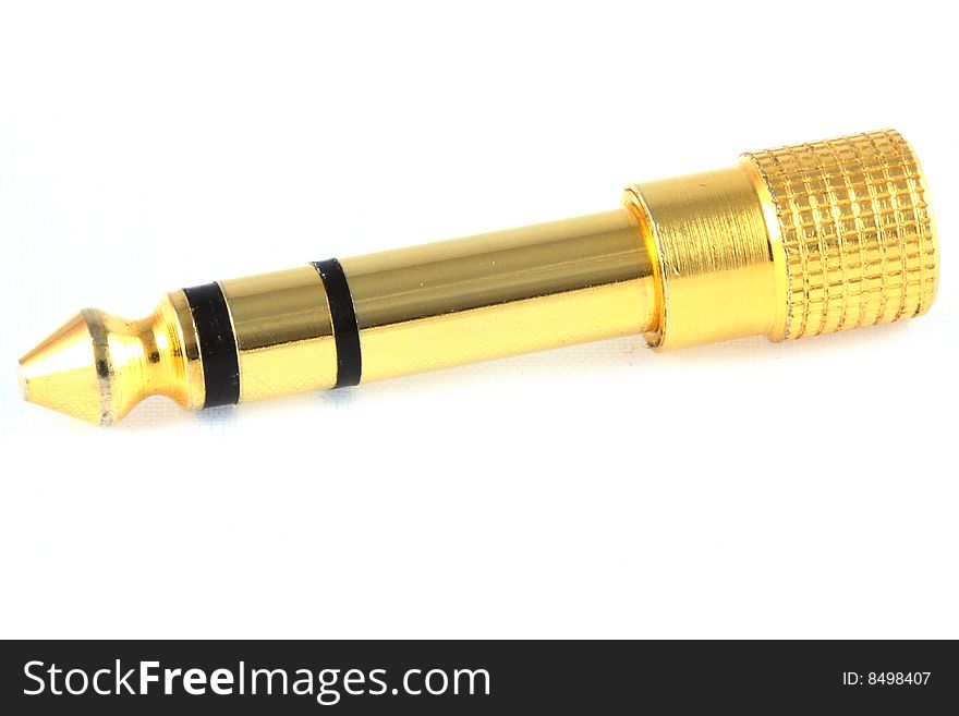 A quarter inch stereo jack plug, gold plated, lying against a white background