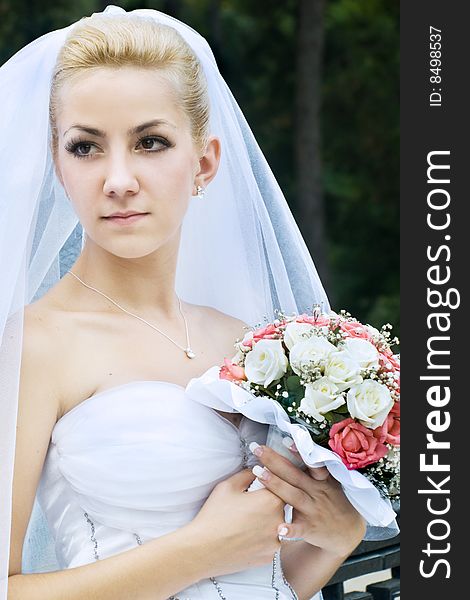Portrait of beautiful bride with bouquet outdoor shot