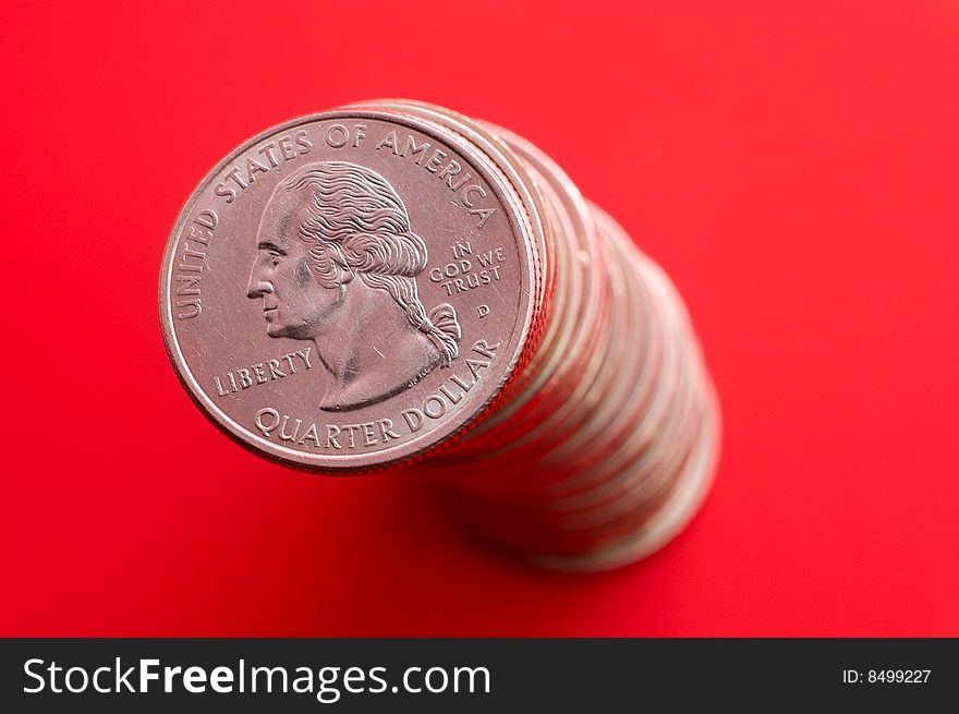 High stack of quarter dollar coins isolated on red. High stack of quarter dollar coins isolated on red