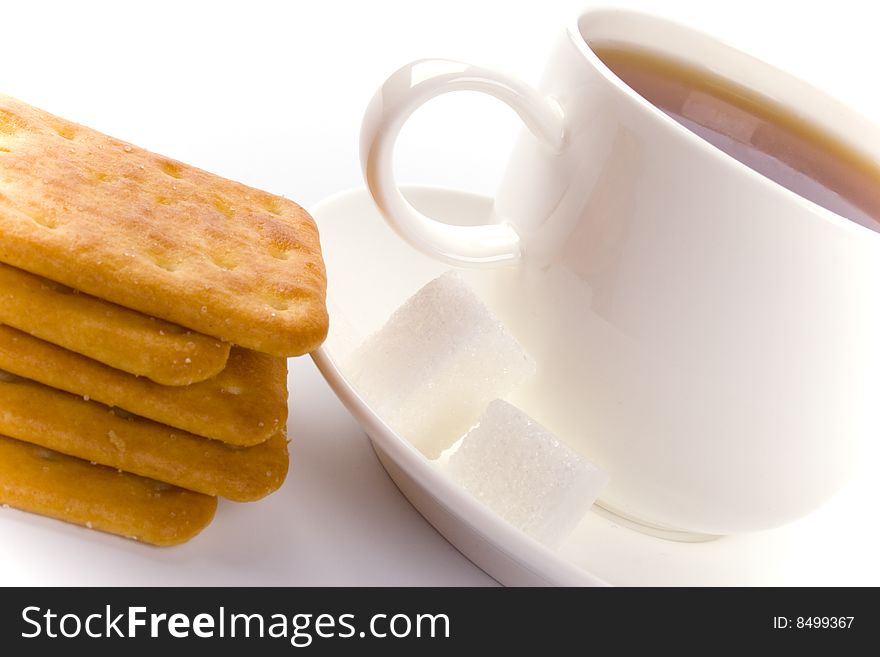 Cup of tea, sugar and cookies closeup on white