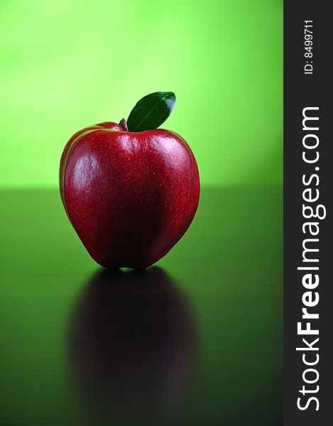 Red apple with leaf on a table