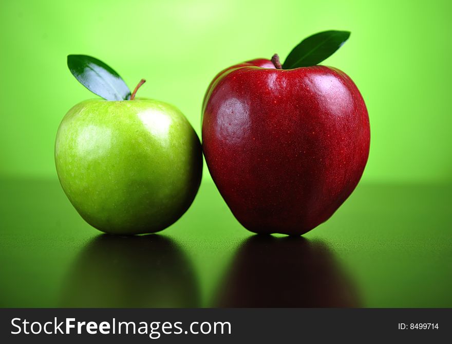 A green and a red apple on a table. A green and a red apple on a table