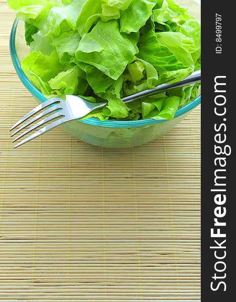 Green salad and a fork in bowl