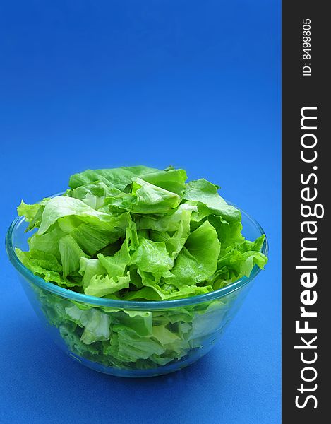 Green salad in bowl on blue background