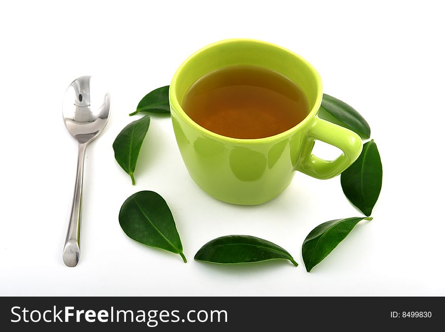 Cup of tea rounded by green leafs
