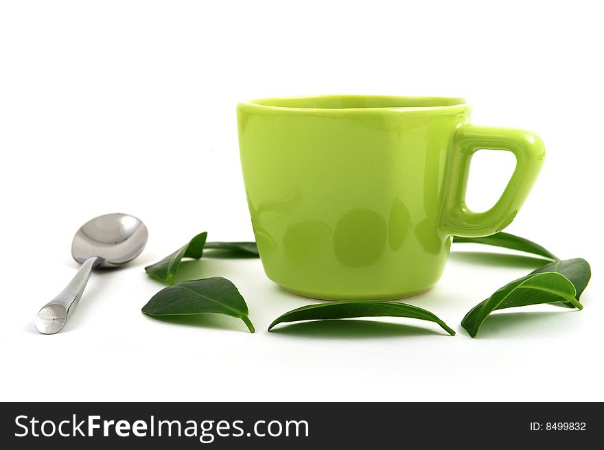 Cup of green tea rounded by leafs
