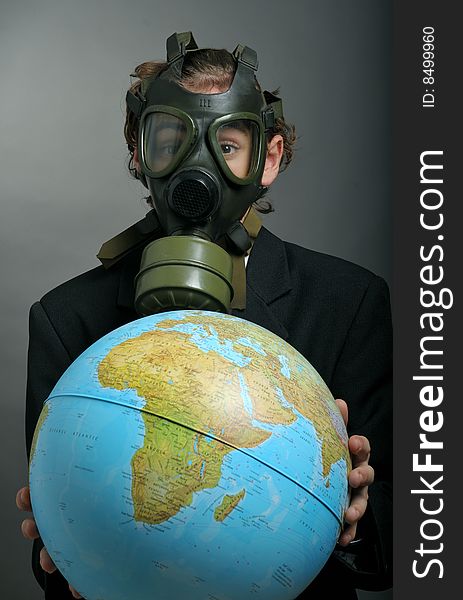 Businessman with gas mask on face holding earth globe. Businessman with gas mask on face holding earth globe