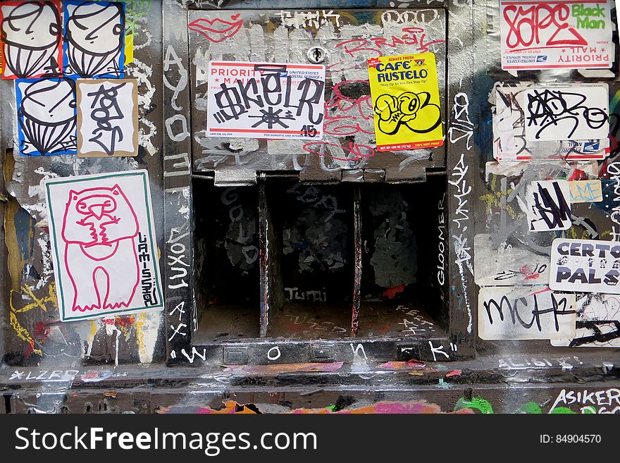sticker-and-graffiti-covered wall with openings