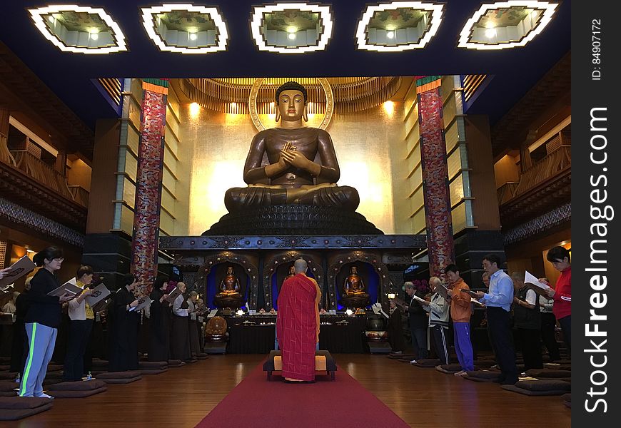 Worshipers Praying To Buddha Statue