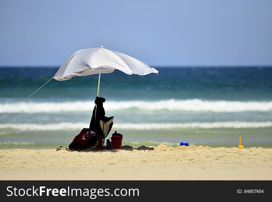 Beach umbrella on sandy seashores on sunny day. Beach umbrella on sandy seashores on sunny day.