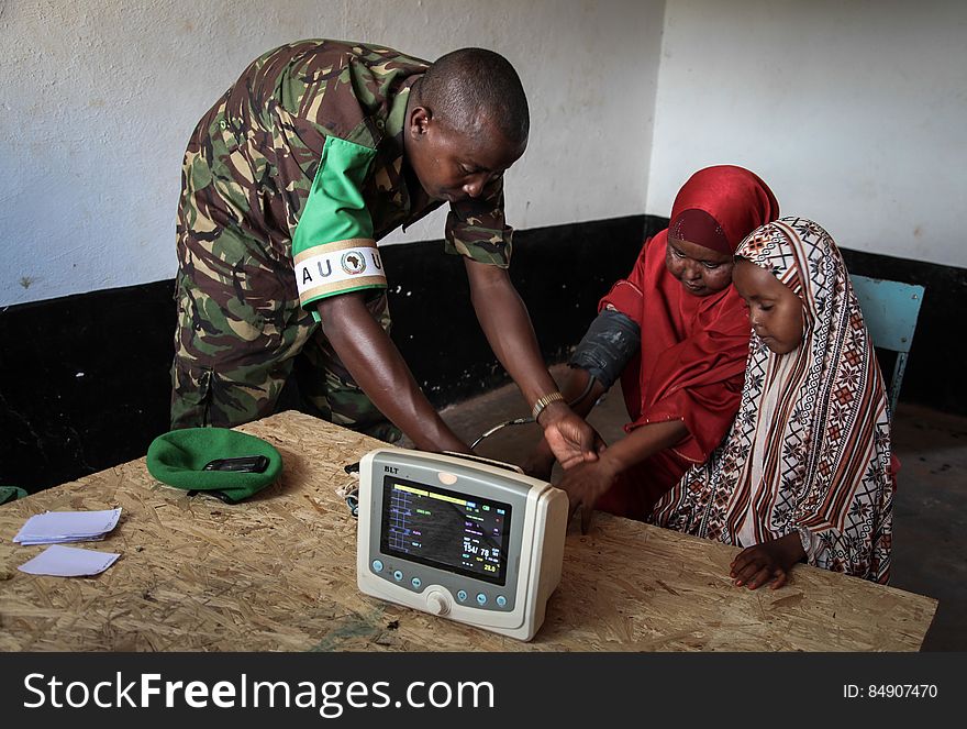 A Kenyan medical officer takes a woman&#x27;s blood pressure at a free medical clinic provided by the Kenyan Contingent serving with the African Union Mission in Somalia &#x28;AMISOM&#x29; in the southern Somali port city of Kismayo, 19 August 2013. Open 7 days a week and seeing an average of 80 patients a day from Kismayo and surrounding villages, AMISOM medical staff provide the free health care to Kismayo&#x27;s civilians, treating a variety of cases including malaria, respiratry tract infections, sexually transmitted infections and occassionally gunshot wounds. AU-UN IST PHOTO / RAMADAAN MOHAMED HASSAN. A Kenyan medical officer takes a woman&#x27;s blood pressure at a free medical clinic provided by the Kenyan Contingent serving with the African Union Mission in Somalia &#x28;AMISOM&#x29; in the southern Somali port city of Kismayo, 19 August 2013. Open 7 days a week and seeing an average of 80 patients a day from Kismayo and surrounding villages, AMISOM medical staff provide the free health care to Kismayo&#x27;s civilians, treating a variety of cases including malaria, respiratry tract infections, sexually transmitted infections and occassionally gunshot wounds. AU-UN IST PHOTO / RAMADAAN MOHAMED HASSAN.