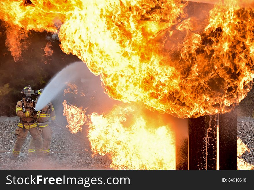 A pair of fire fighters putting out a conflagration.