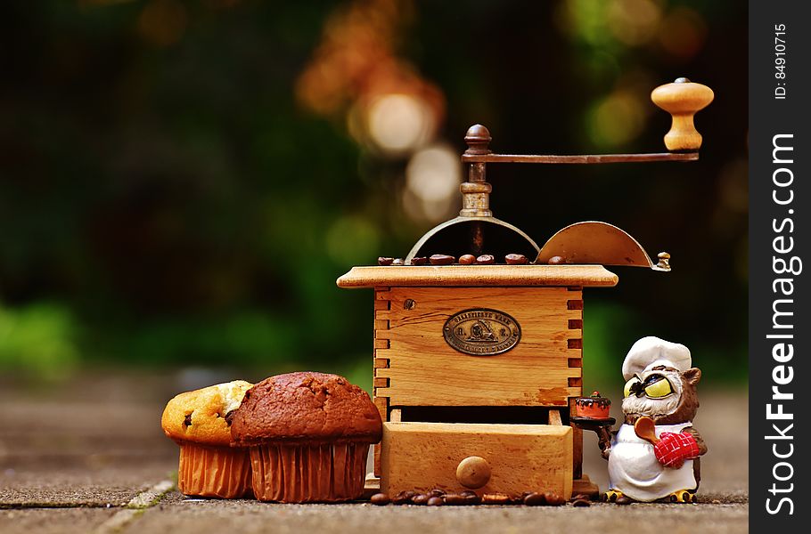 A vintage coffee mill and couple of cupcakes. A vintage coffee mill and couple of cupcakes.