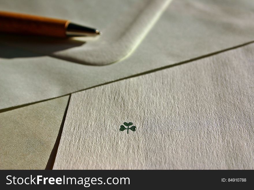 A drawing of a three leaved clover with an envelope and a pen. A drawing of a three leaved clover with an envelope and a pen.
