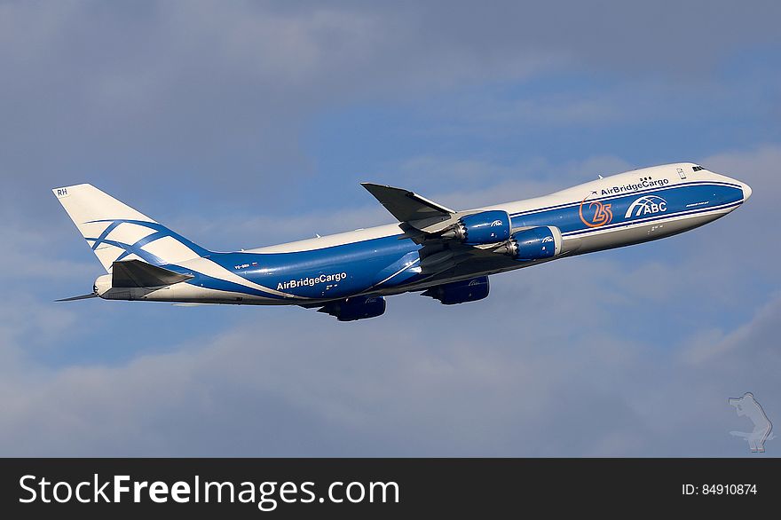 An AirBridgeCargo Boeing 747 plane taking off on blue skies.