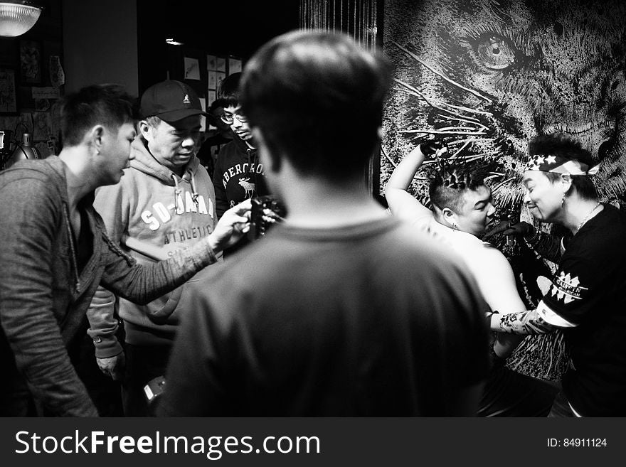 A group of Asian men in a tattoo parlor.