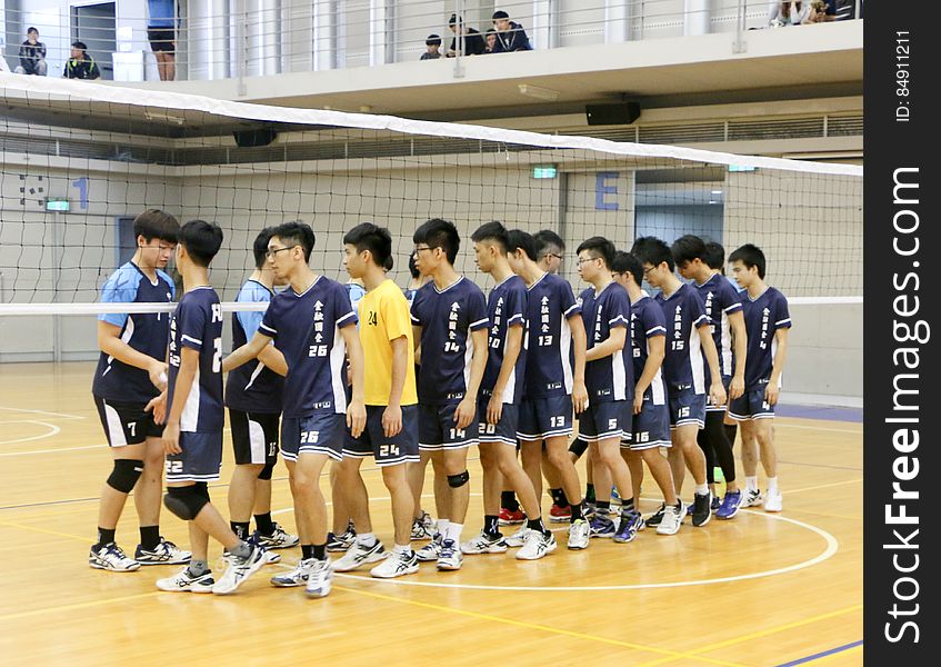 Teams greeting on court during youth volleyball game.