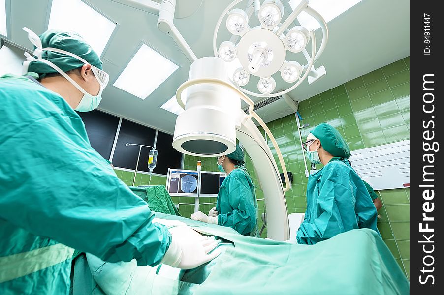 Doctors operating on a patient in an operating room. Doctors operating on a patient in an operating room.