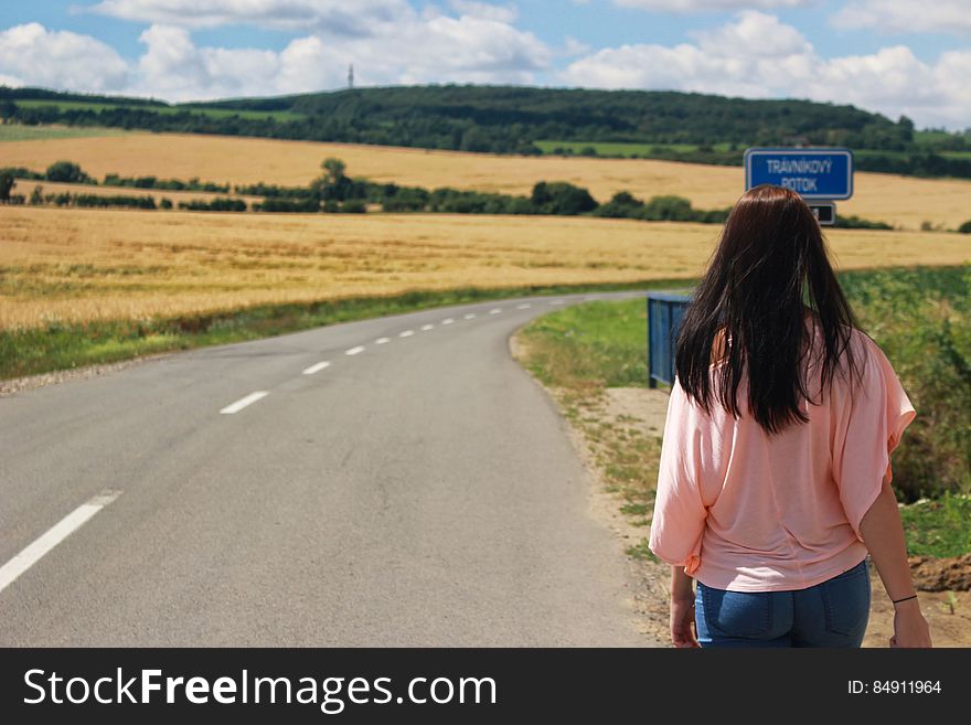Back View of Woman on Road Against Sky