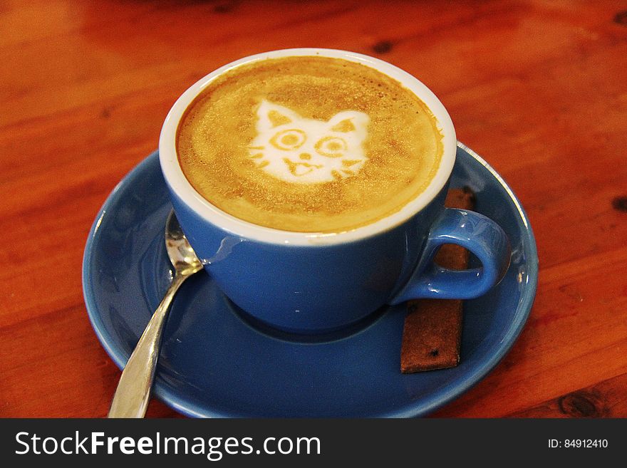 A cup of coffee with latte art of a cat.